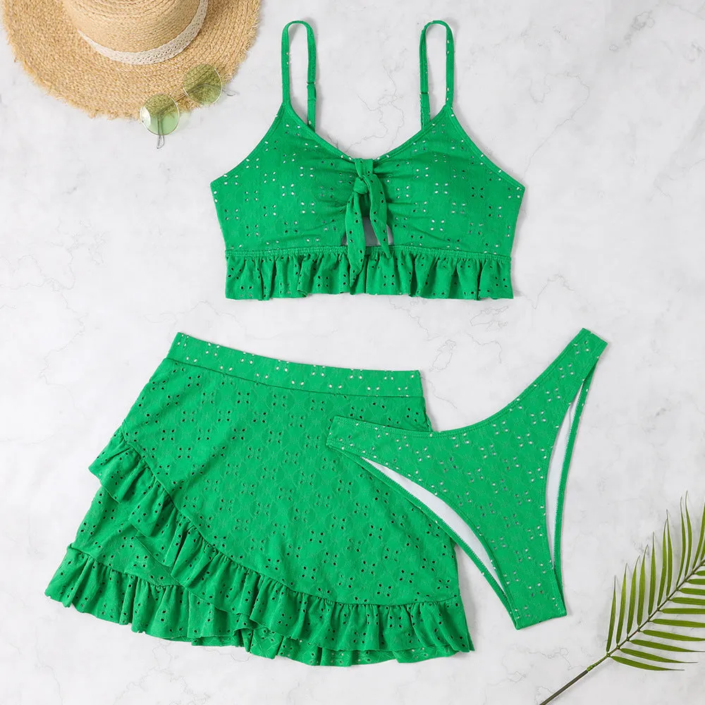 Women's solid colour split hip skirt bikini swimsuit three-piece set on a mannequin.