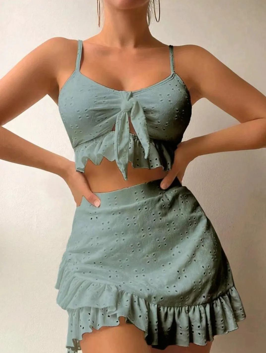 Women's solid colour split hip skirt bikini swimsuit three-piece set on a mannequin.