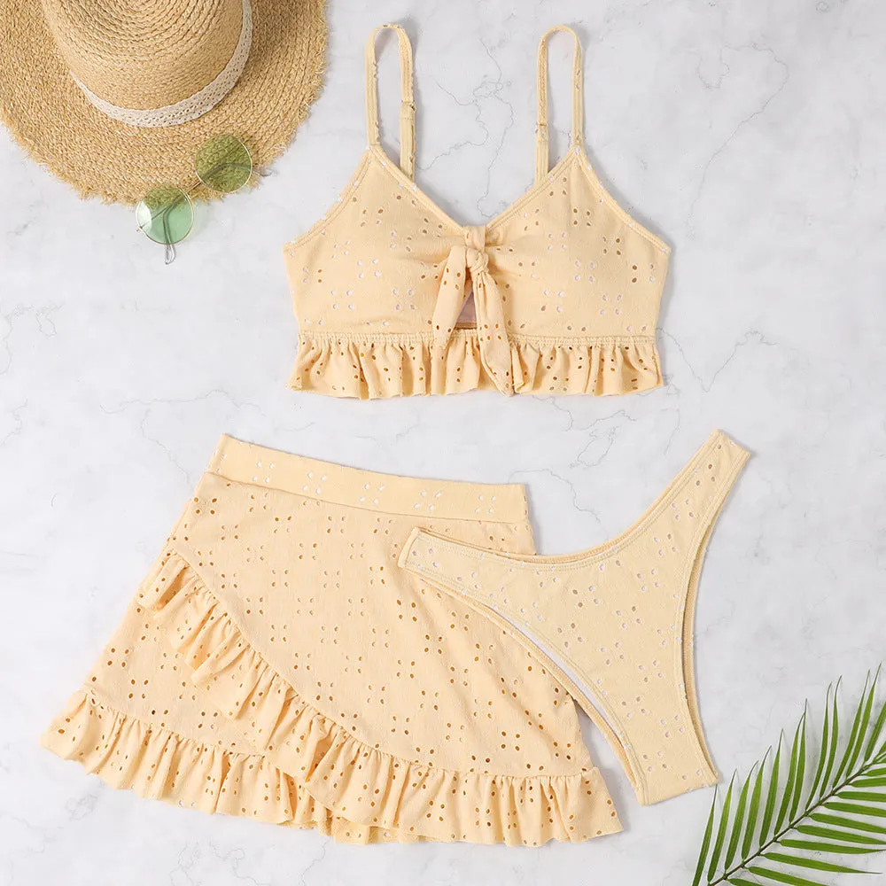 Women's solid colour split hip skirt bikini swimsuit three-piece set on a mannequin.