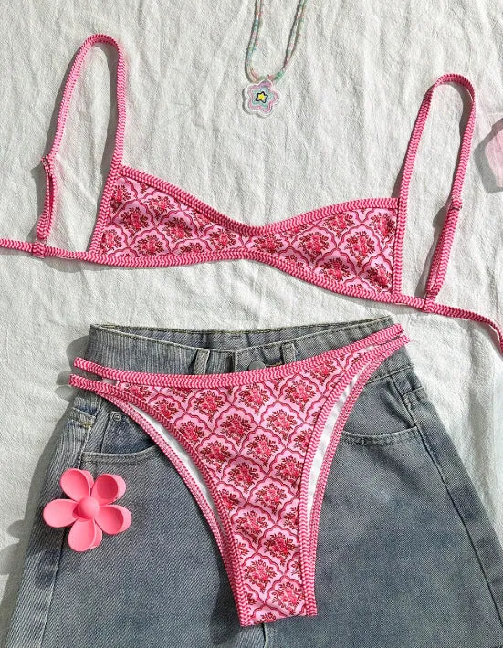 Printed pink split bikini set with exposed back and adjustable shoulder straps on woman