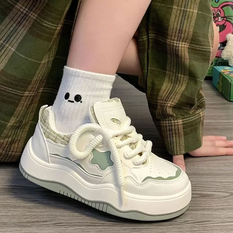 Women's green patent leather platform sneakers with round toe and lace-up closure on rubber sole
