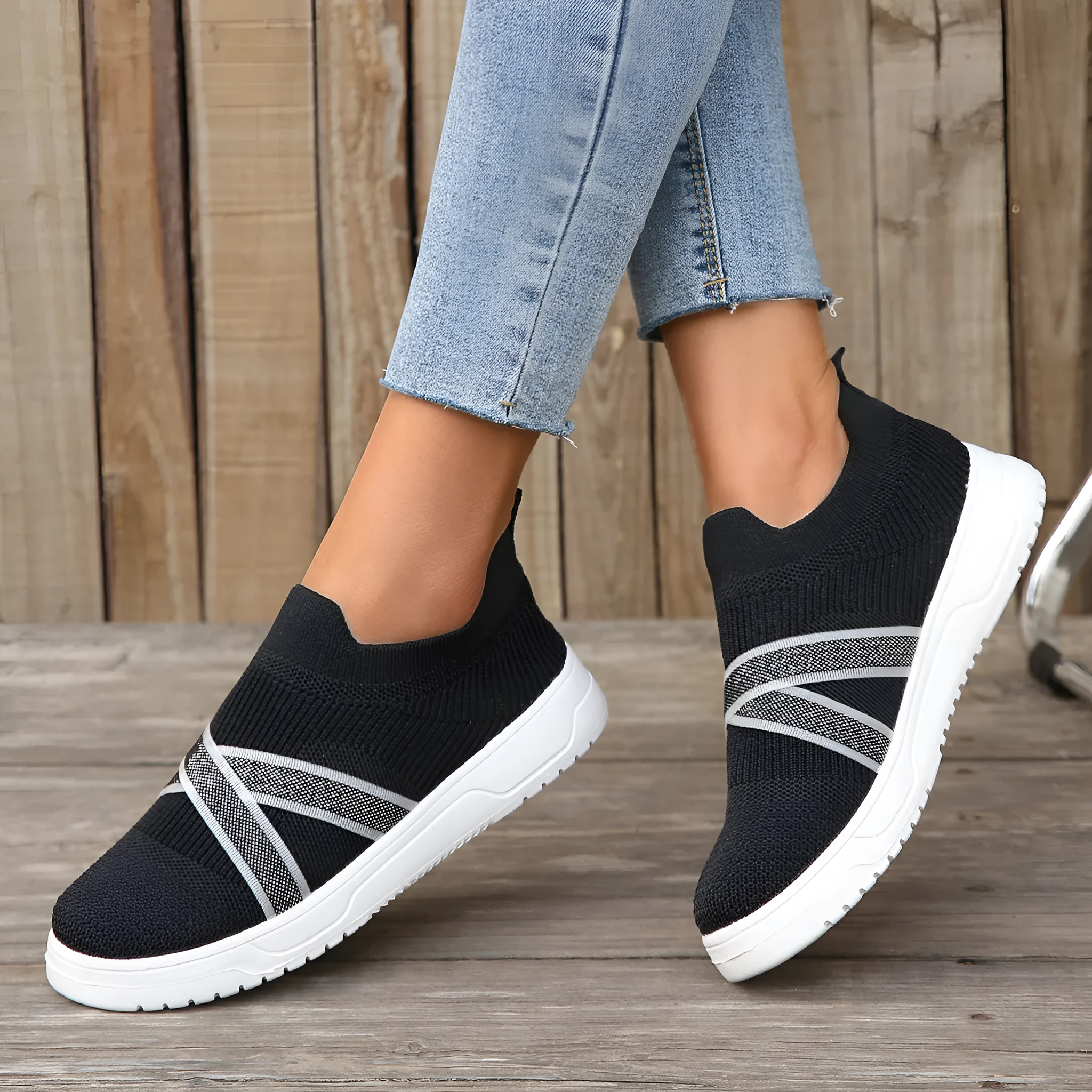 Black women's flat shoes with flyknit mesh upper, round toe, tassel detail, and flat rubber sole.