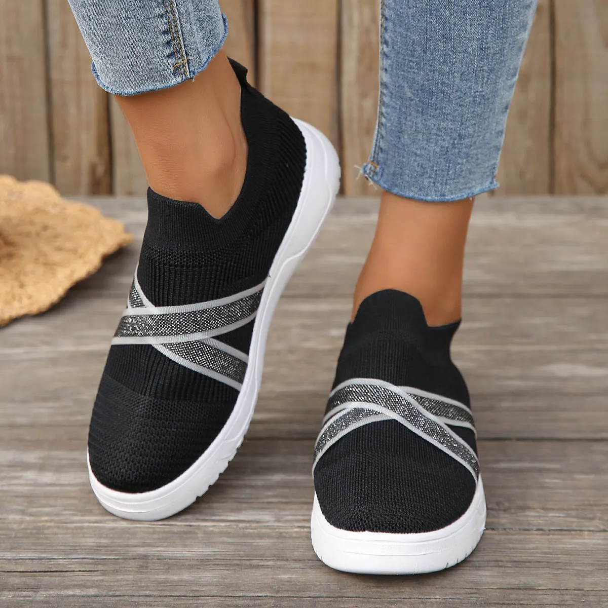 Black women's flat shoes with flyknit mesh upper, round toe, tassel detail, and flat rubber sole.