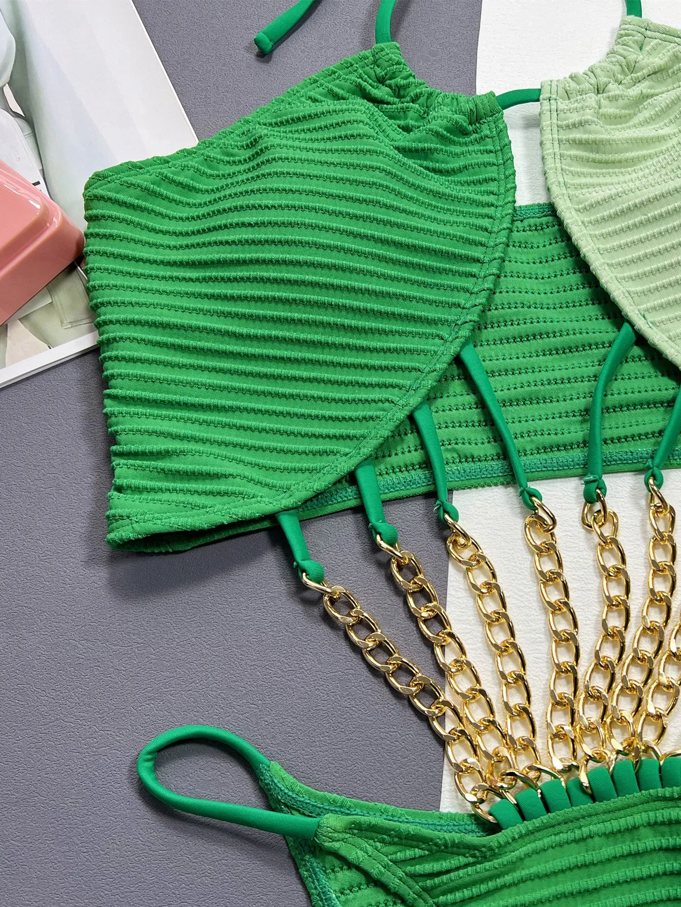 Green women's one-piece swimsuit with a hollow cutout design on a mannequin