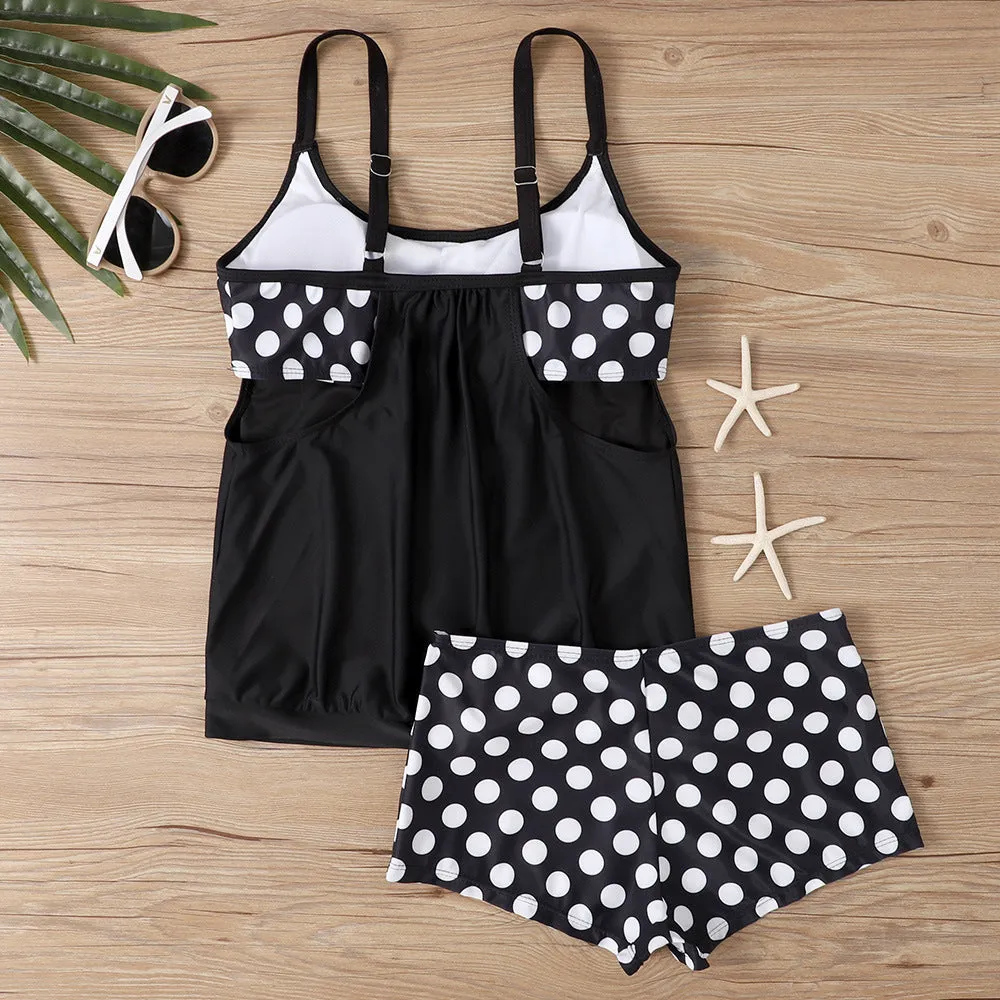 Women's black polka dot high-waisted boxer swimsuit set shown on a model.