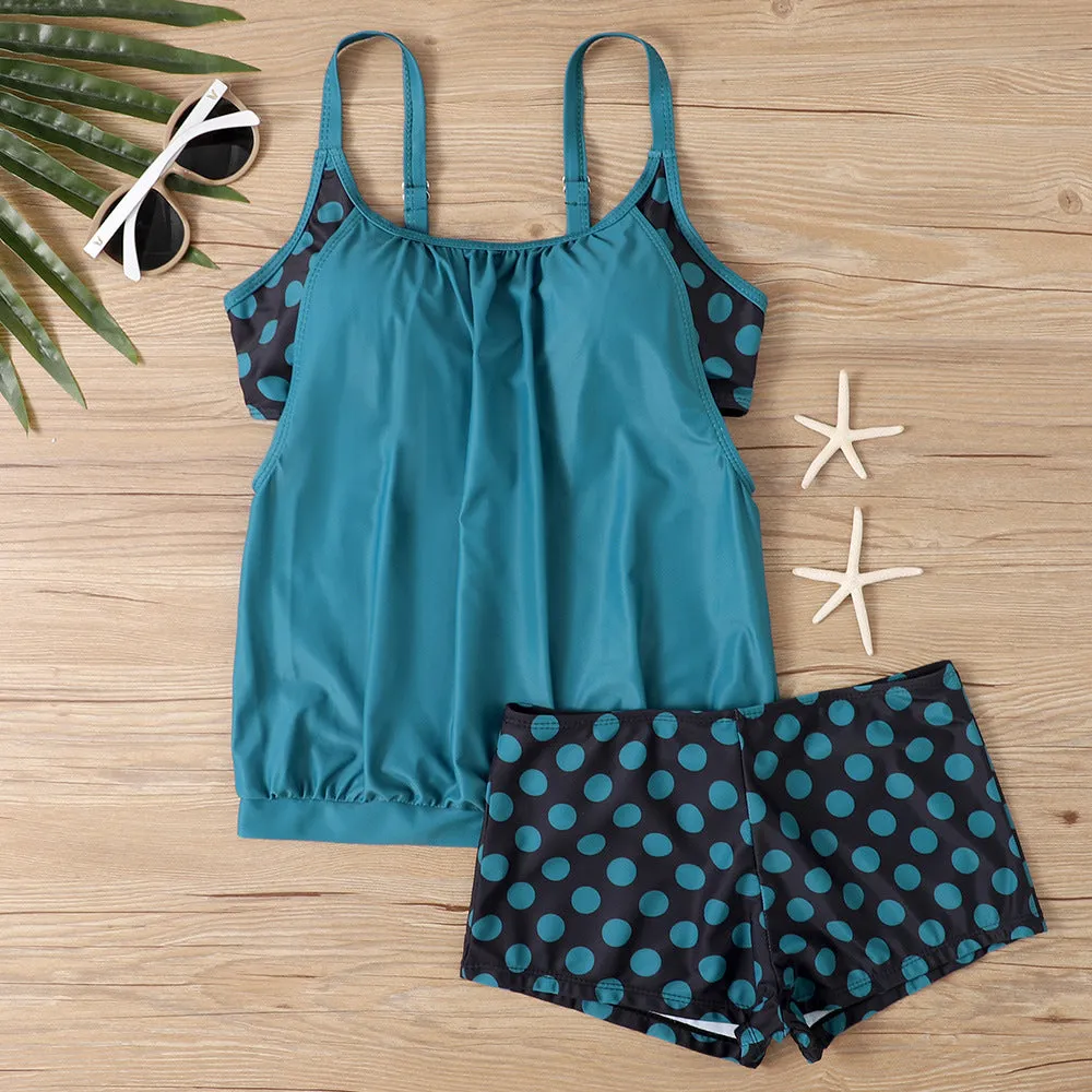 Women's black polka dot high-waisted boxer swimsuit set shown on a model.