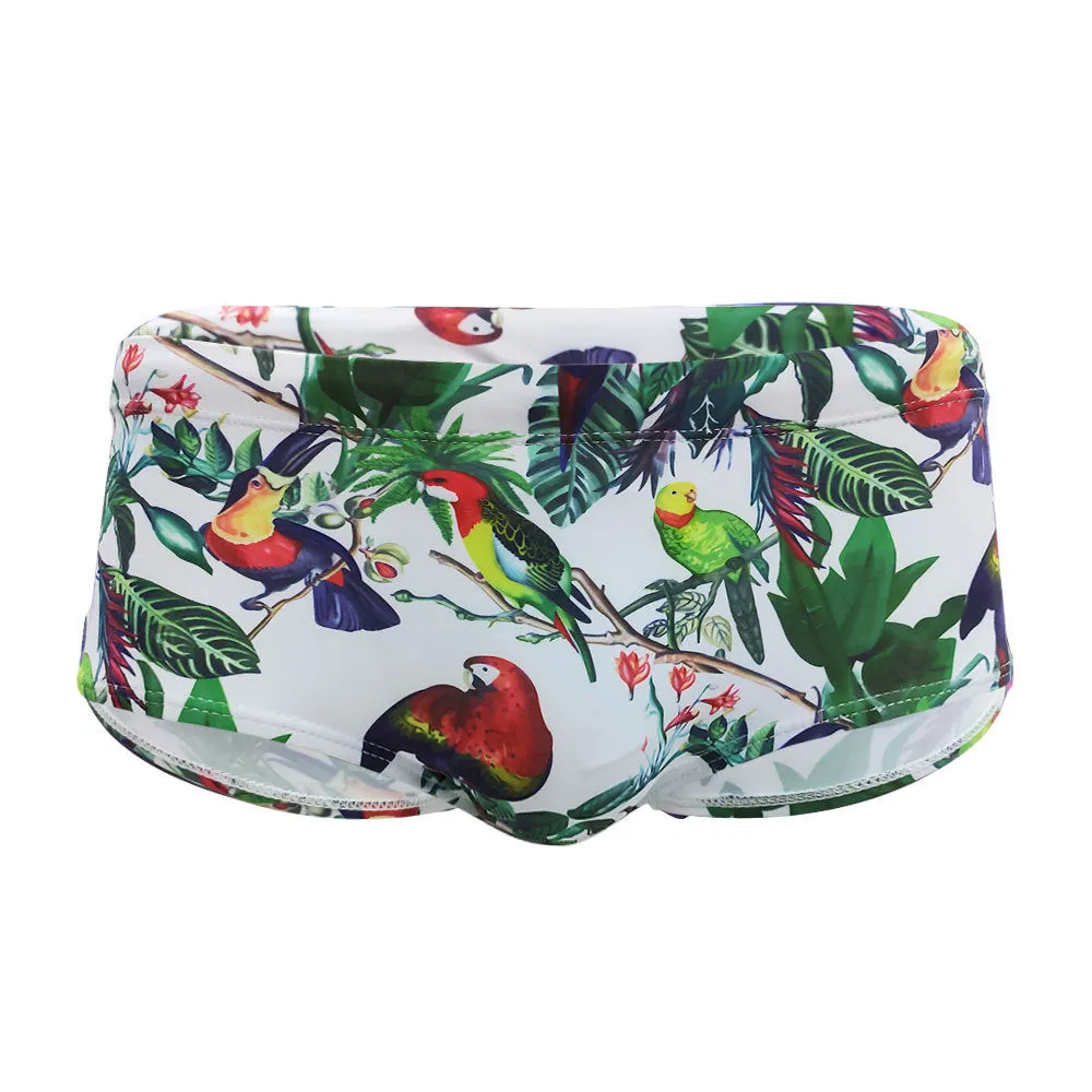 Men's blue swimming trunks with a detailed floral and bird print pattern, small boxer style