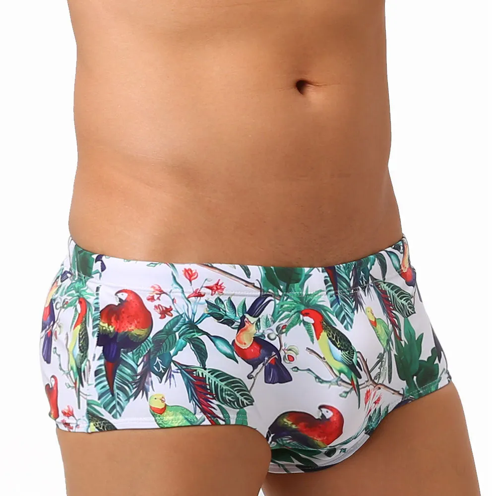 Men's blue swimming trunks with a detailed floral and bird print pattern, small boxer style