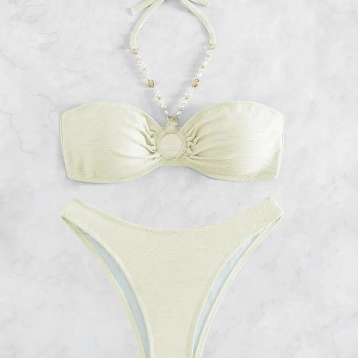 Women's solid colour halter bikini set in creamy-white, shown front-on.