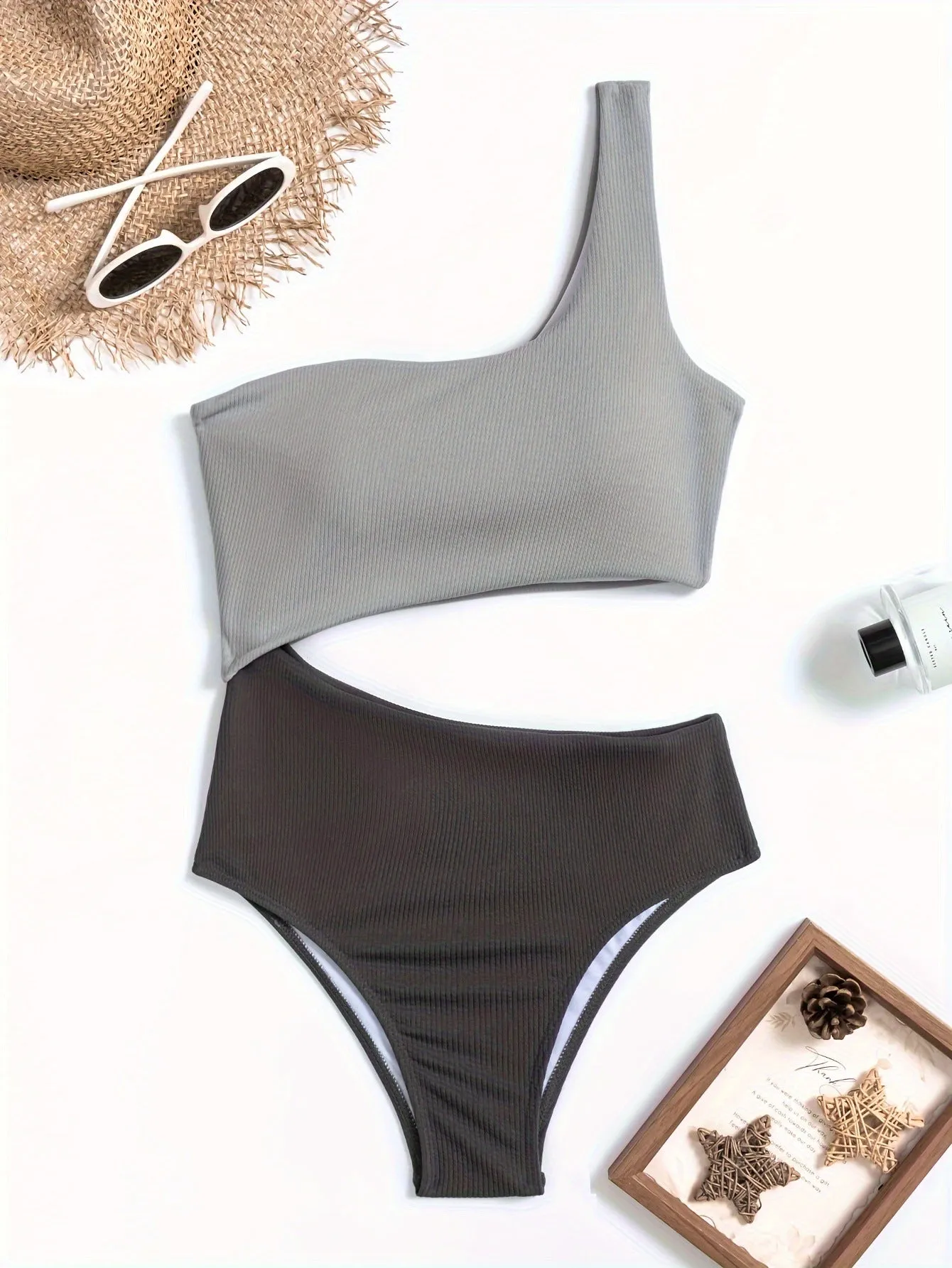 Light gray one-shoulder one-piece swimsuit on a white background.