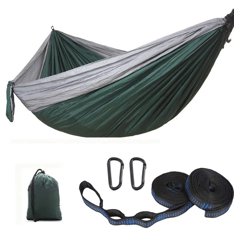 Parachute cloth camping hammock in 210T nylon hanging between trees with included ropes and buckles
