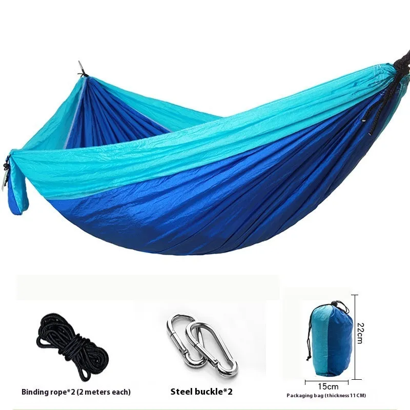 Parachute cloth camping hammock in 210T nylon hanging between trees with included ropes and buckles