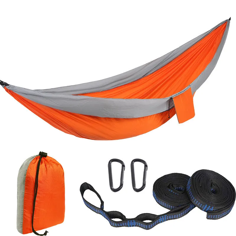 Parachute cloth camping hammock in 210T nylon hanging between trees with included ropes and buckles
