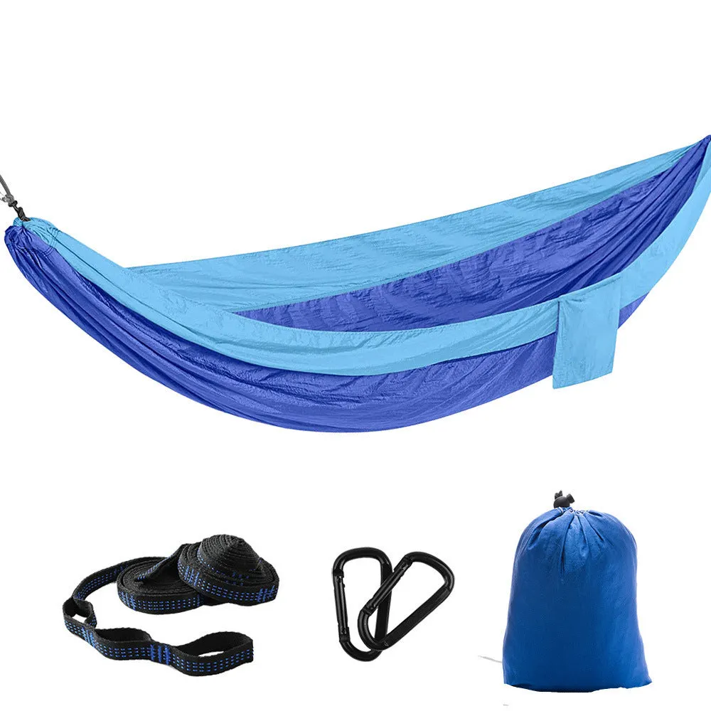 Parachute cloth camping hammock in 210T nylon hanging between trees with included ropes and buckles