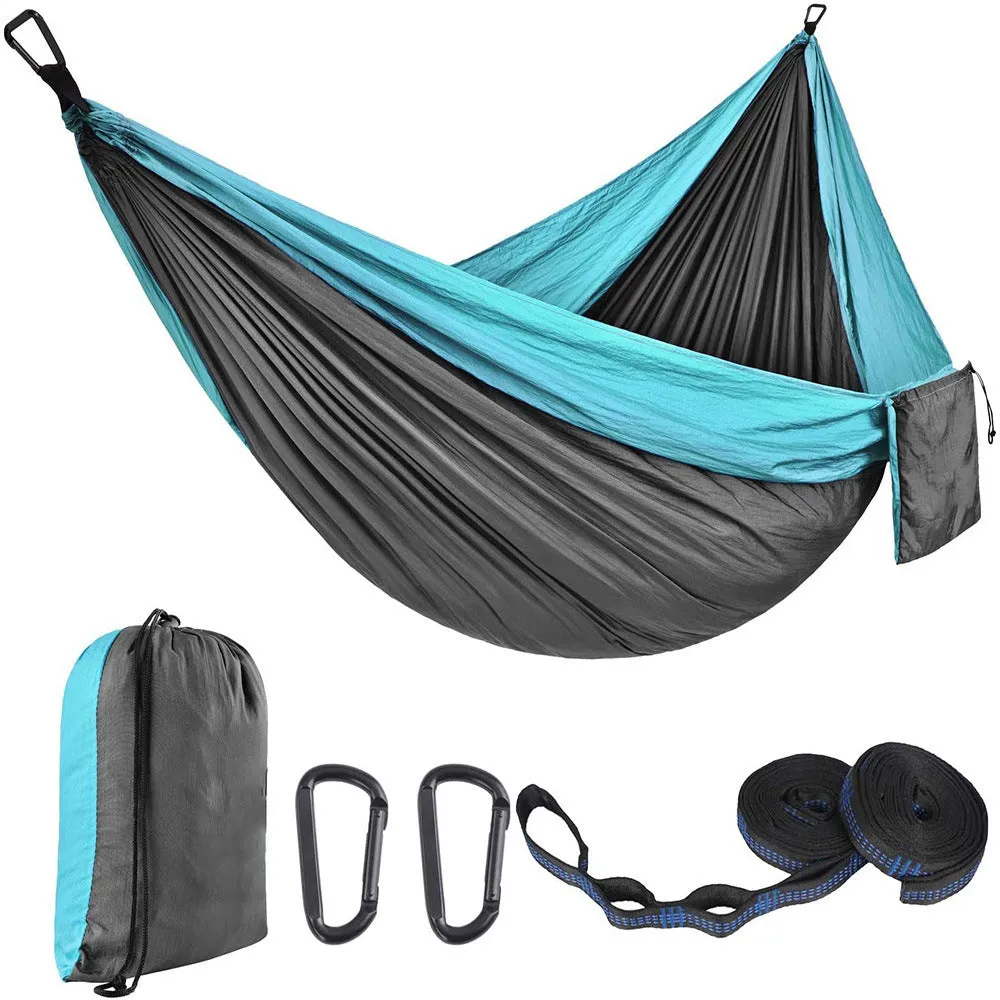 Parachute cloth camping hammock in 210T nylon hanging between trees with included ropes and buckles