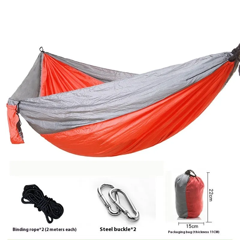 Parachute cloth camping hammock in 210T nylon hanging between trees with included ropes and buckles