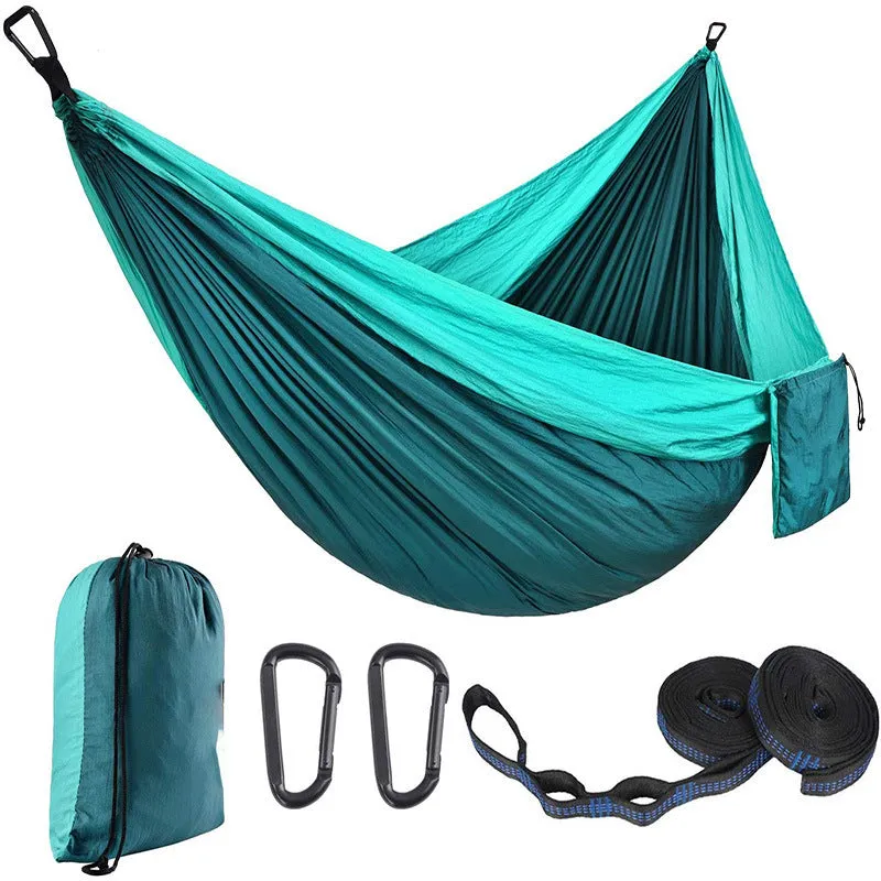 Parachute cloth camping hammock in 210T nylon hanging between trees with included ropes and buckles