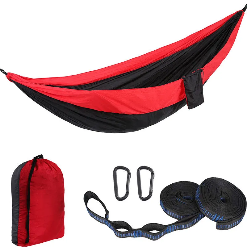 Parachute cloth camping hammock in 210T nylon hanging between trees with included ropes and buckles