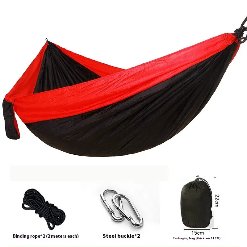 Parachute cloth camping hammock in 210T nylon hanging between trees with included ropes and buckles