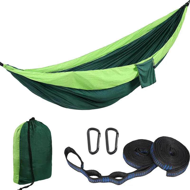 Parachute cloth camping hammock in 210T nylon hanging between trees with included ropes and buckles