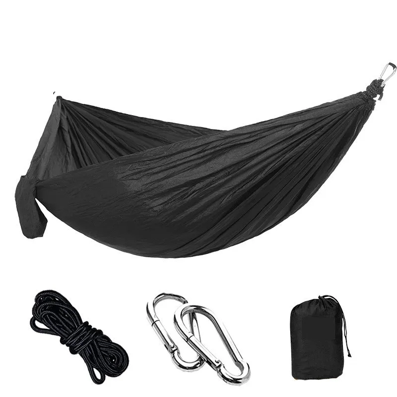 Parachute cloth camping hammock in 210T nylon hanging between trees with included ropes and buckles