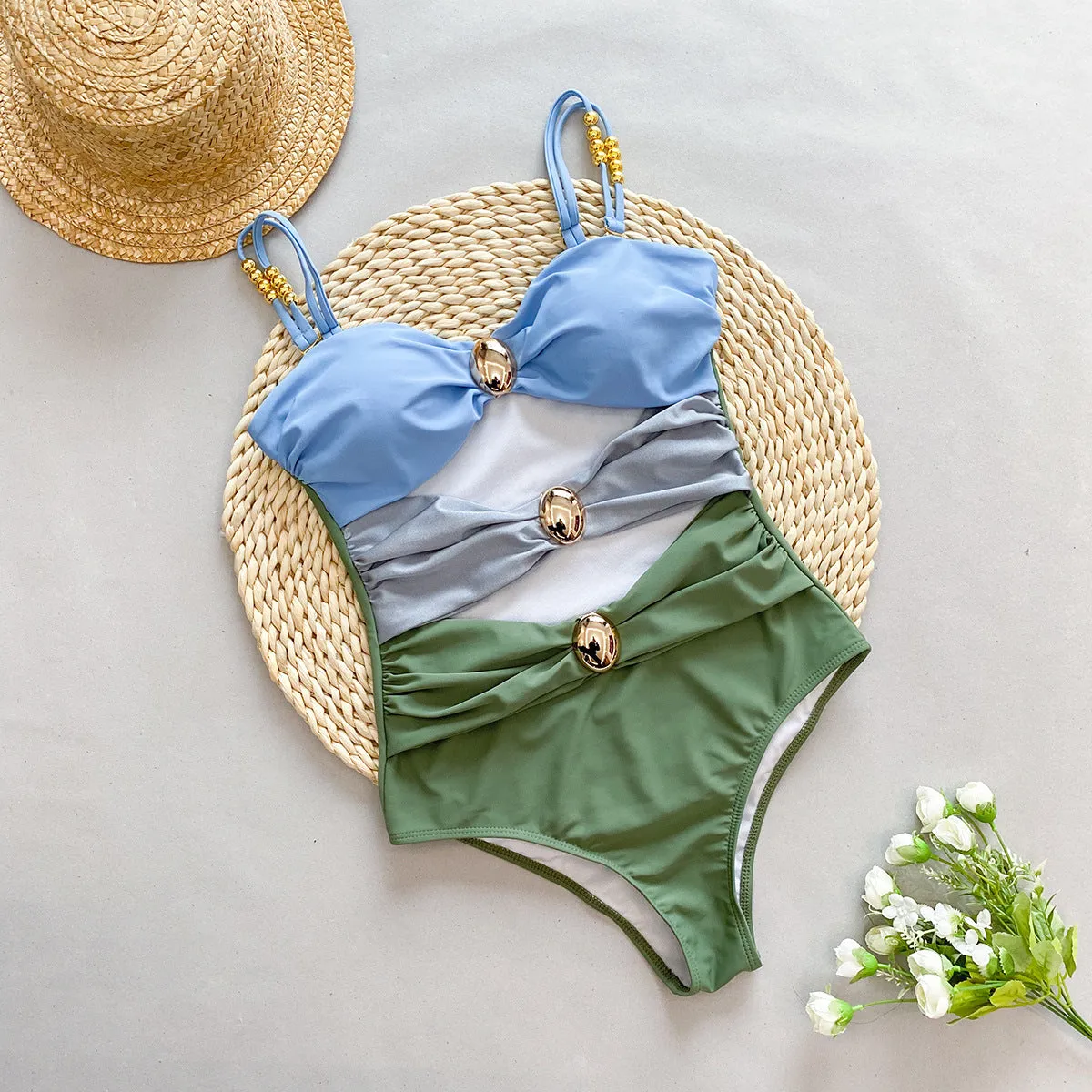 Women's brown one-piece swimsuit with a matching detachable beige skirt laid flat.