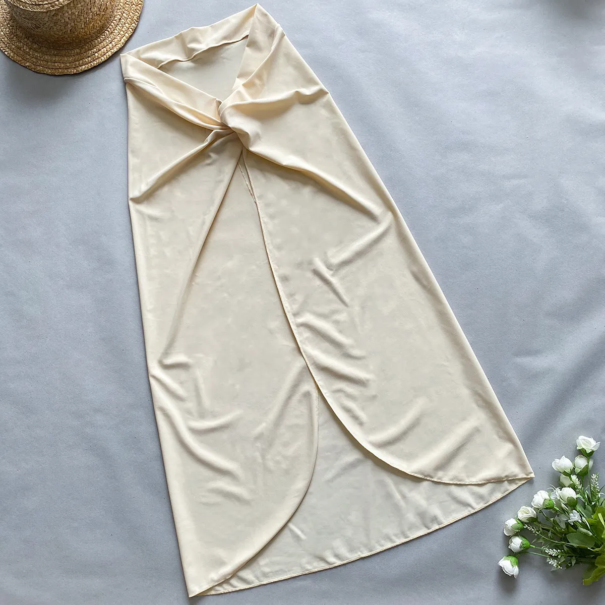 Women's brown one-piece swimsuit with a matching detachable beige skirt laid flat.