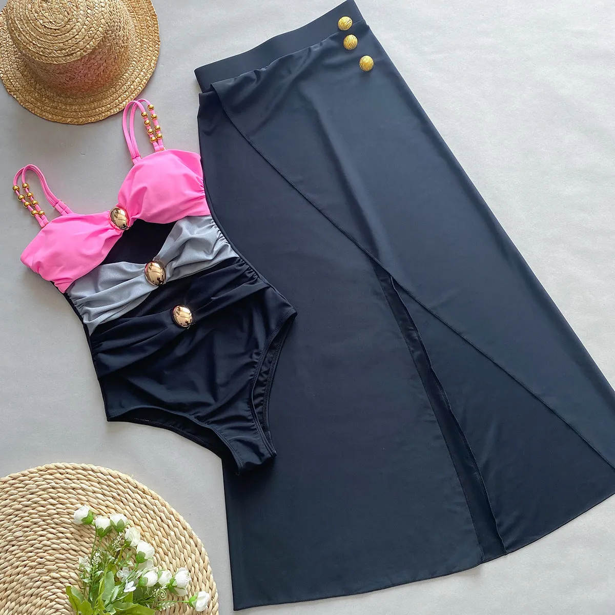 Women's brown one-piece swimsuit with a matching detachable beige skirt laid flat.