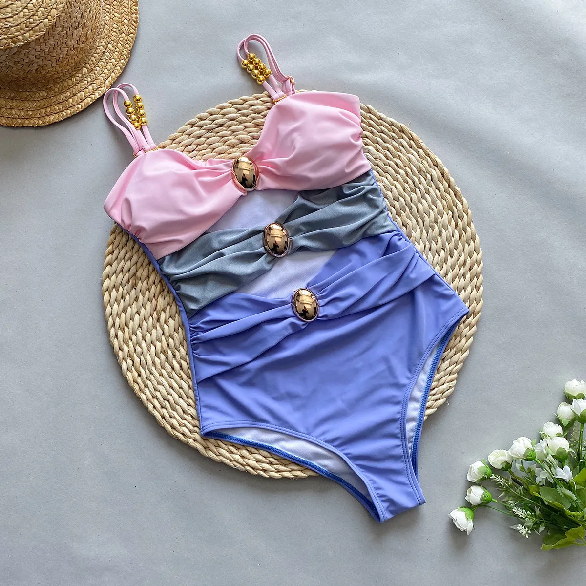 Women's brown one-piece swimsuit with a matching detachable beige skirt laid flat.