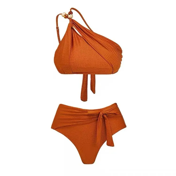 Women's brown push up high waist swimsuit with a split brief design and a sheer black chiffon dress overlay.