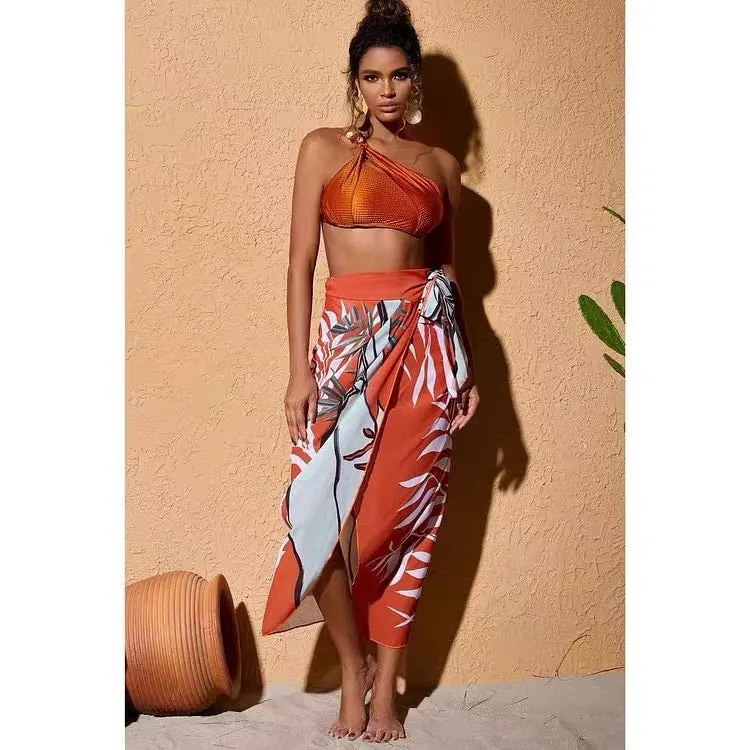 Women's brown push up high waist swimsuit with a split brief design and a sheer black chiffon dress overlay.