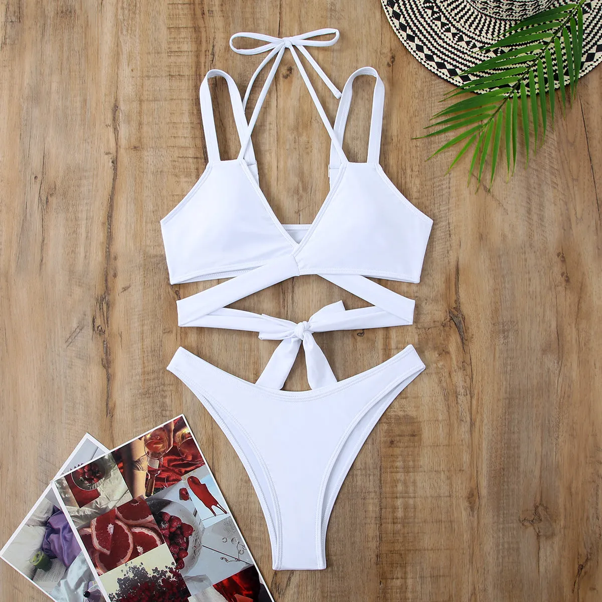 Women's solid colour strap bikini swimsuit on a hanger, shown in red.