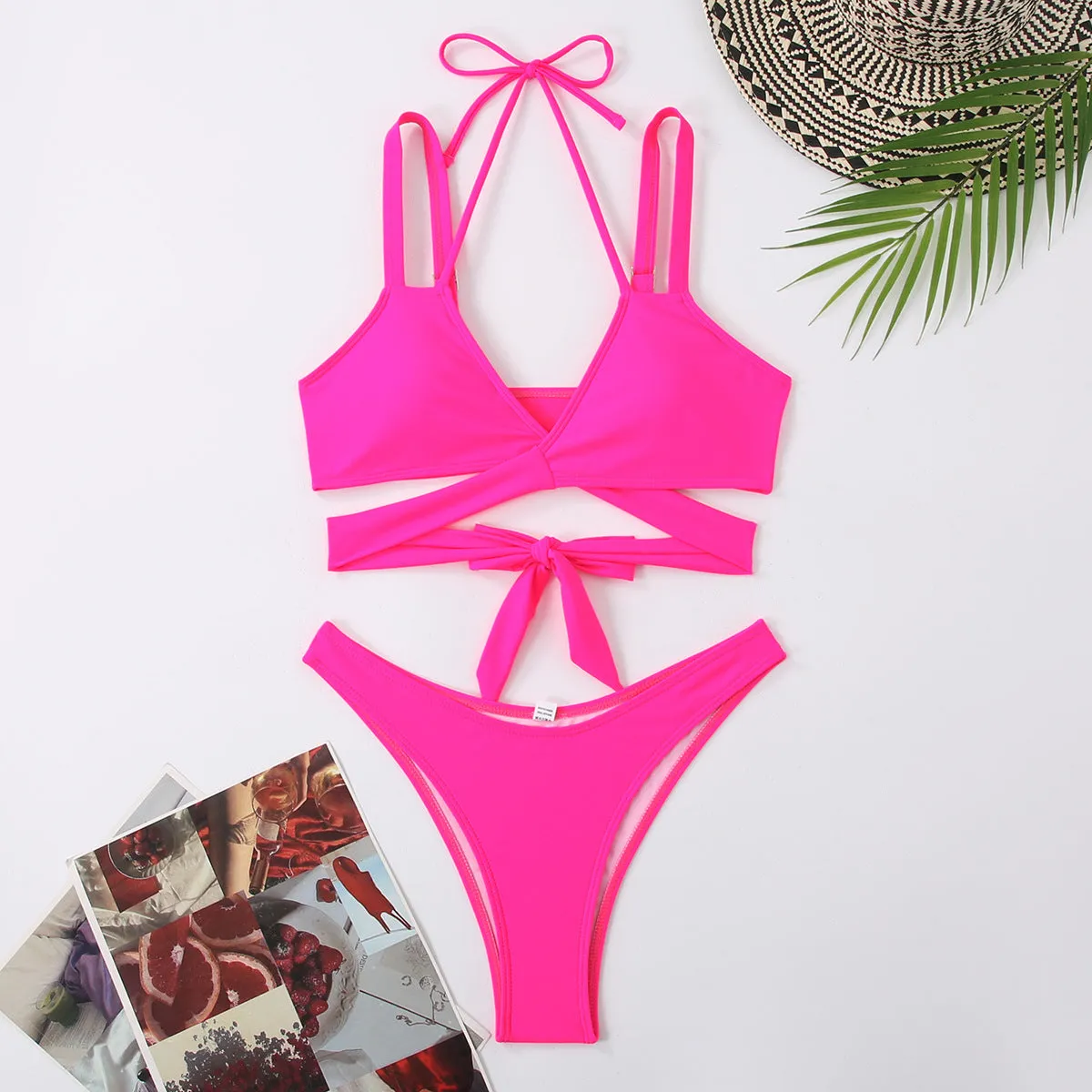 Women's solid colour strap bikini swimsuit on a hanger, shown in red.