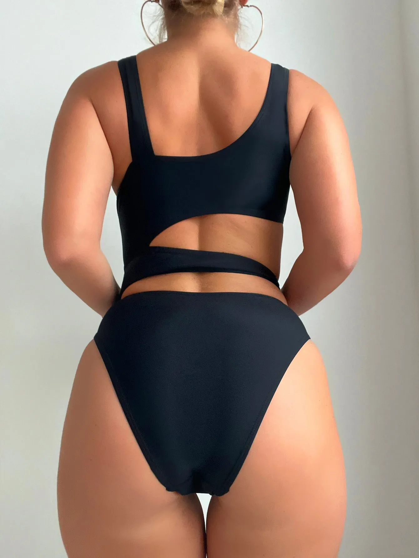 Black solid colour women's one-piece swimsuit with a high cut Siamese style and sleeveless design.