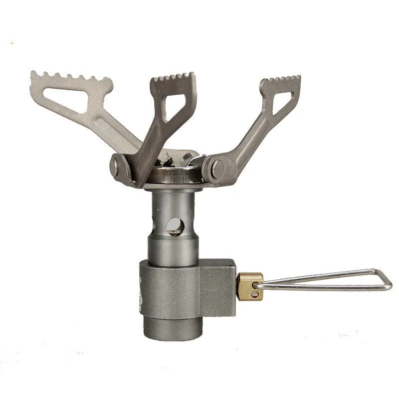 Compact one-piece propane camping stove on rocky ground, fuel canister attached, with a pot boiling.