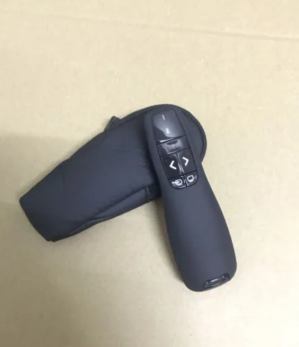 Black wireless presenter pen with laser pointer and slide control buttons next to its small USB receiver.