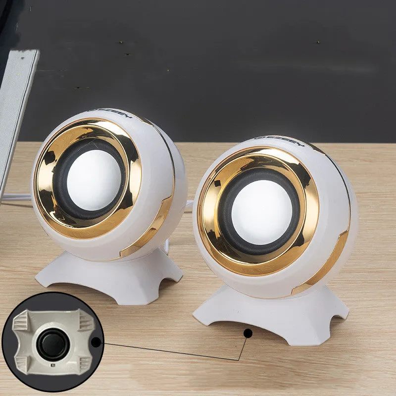 Compact black and gold USB-powered desktop stereo speakers next to a laptop.