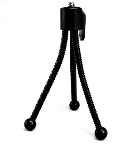 Small black iron frame mini tripod with folded legs and a ball head, shown next to a smartphone.