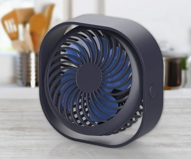 A small, modern USB desk fan in blue with a rotating head on a white desk.