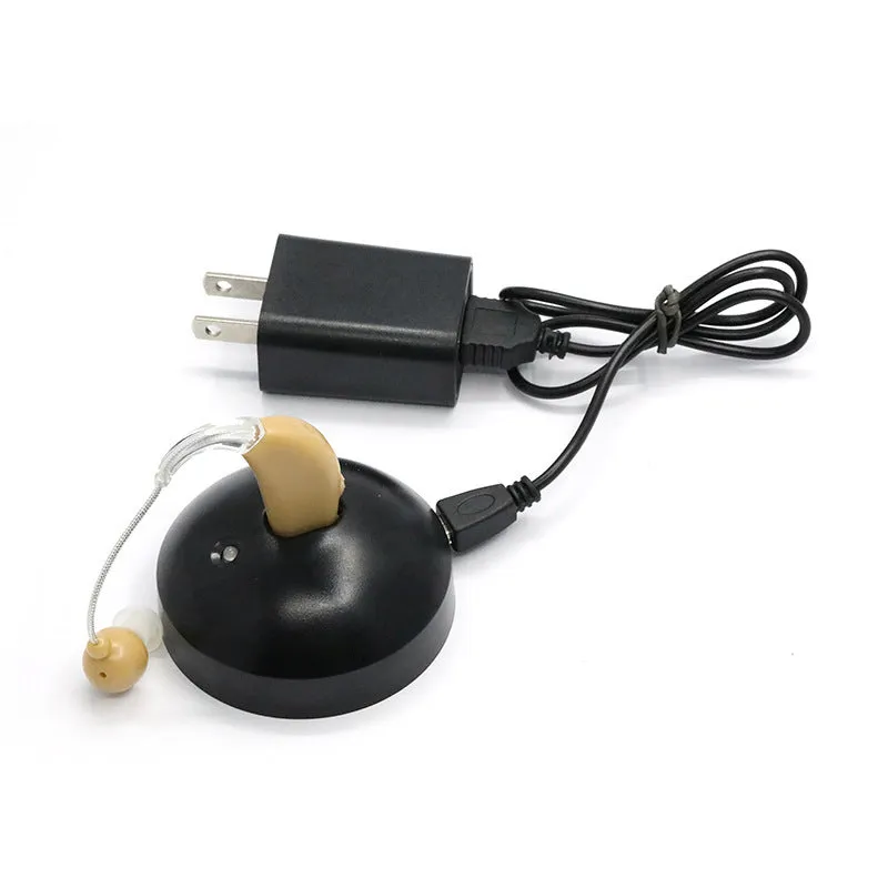 Black silicone rechargeable hearing aid amplifier with charging cable on a plain surface.