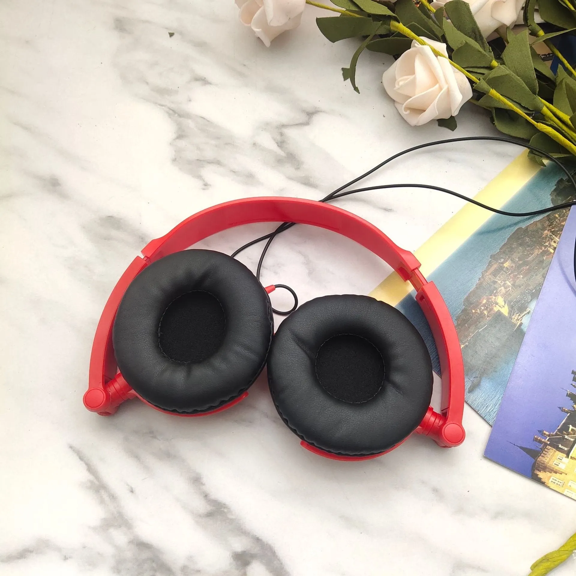 Black over-ear wired headphones with adjustable headband shown in folded and unfolded positions