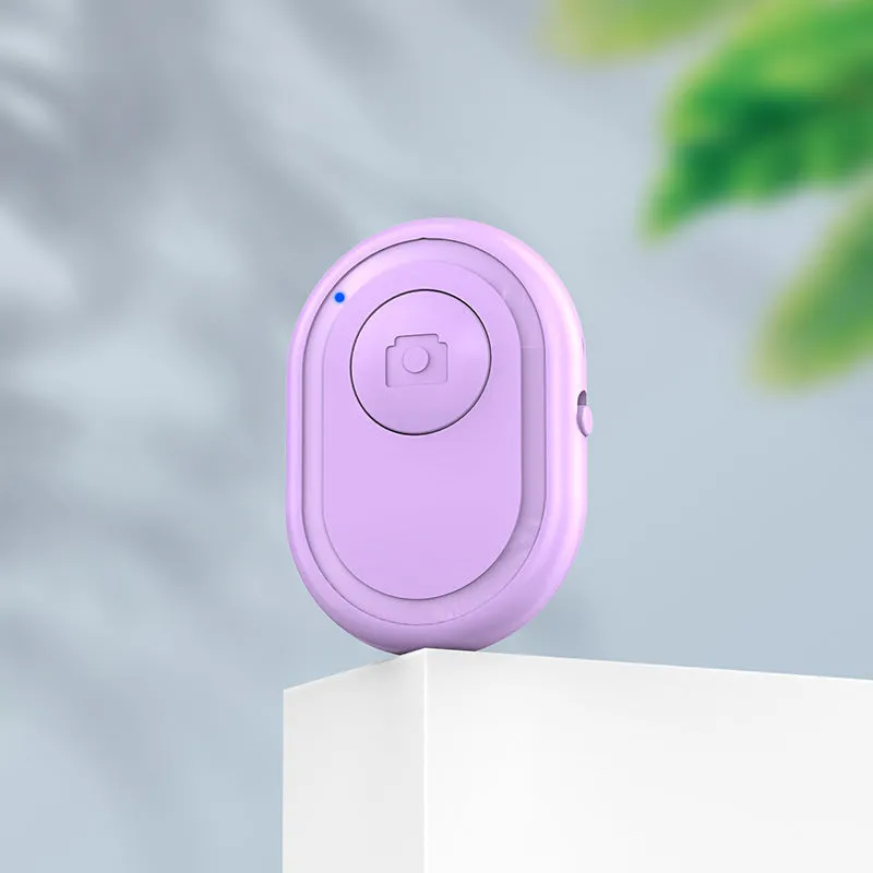 Wireless Bluetooth photo remote control in black, pink, or purple colours showing compact size