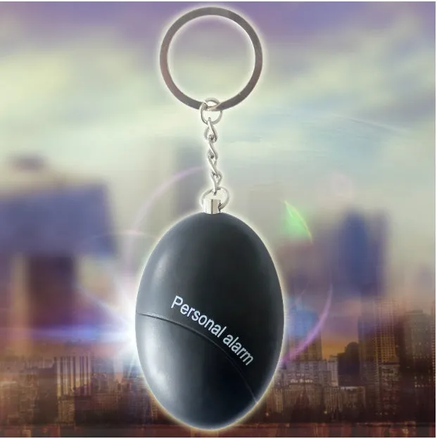Compact keychain personal alarm in colours like black, blue, or pink showing the pull-out activation tab.
