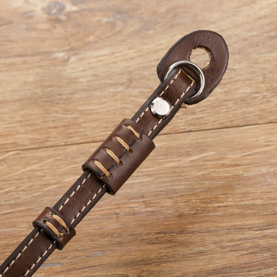 Adjustable black leather camera wrist strap attached to a digital camera body