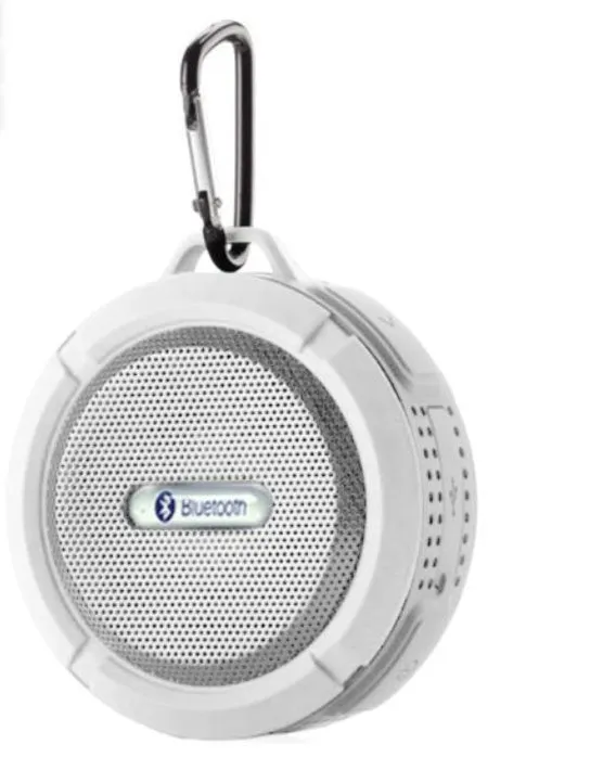 White waterproof Bluetooth speaker with a large clear suction cup mounted on a tiled wall.