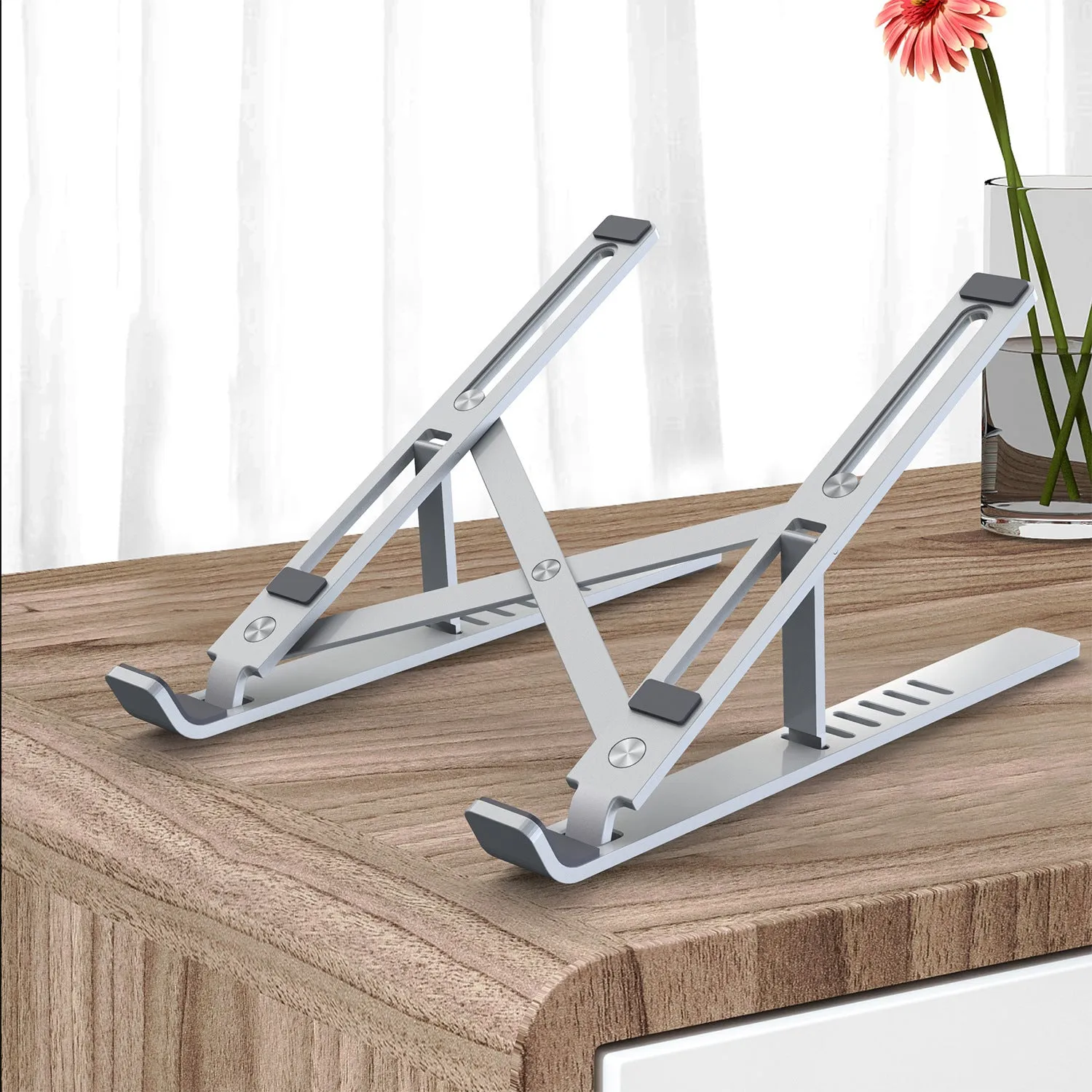 Silver aluminium laptop stand folded flat showing magnetic catch and adjustment gears