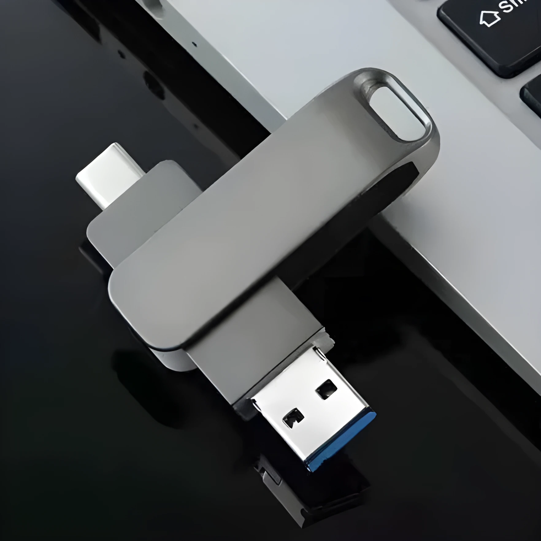 Rotating metal USB flash drive showing USB and USB-C connectors with black finish and protective iron box packaging