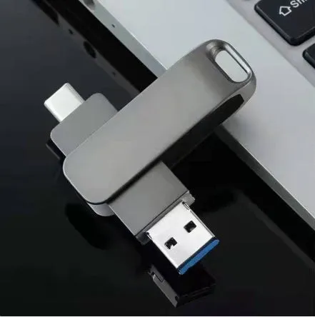 Rotating metal USB flash drive showing USB and USB-C connectors with black finish and protective iron box packaging