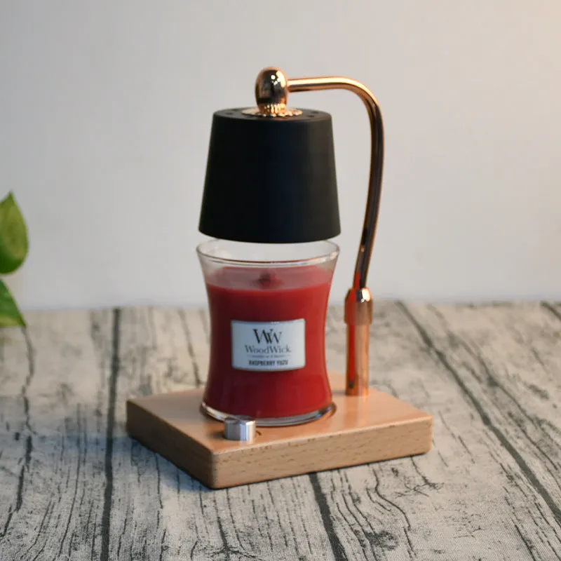A black wooden aromatherapy wax lamp holding a candle on a bedroom surface.