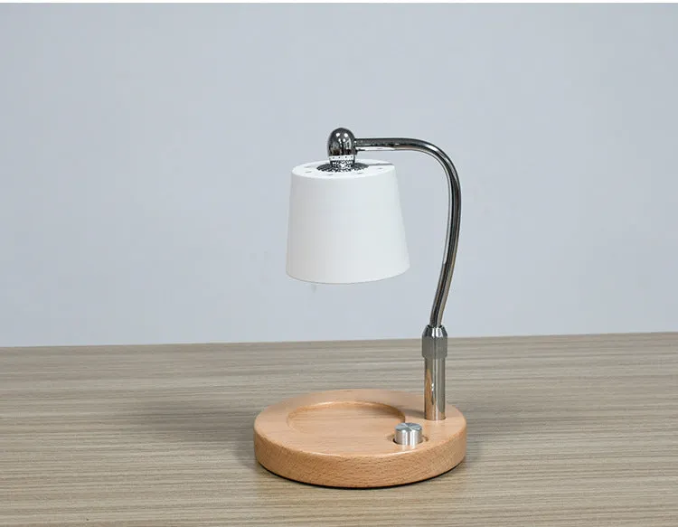 A black wooden aromatherapy wax lamp holding a candle on a bedroom surface.